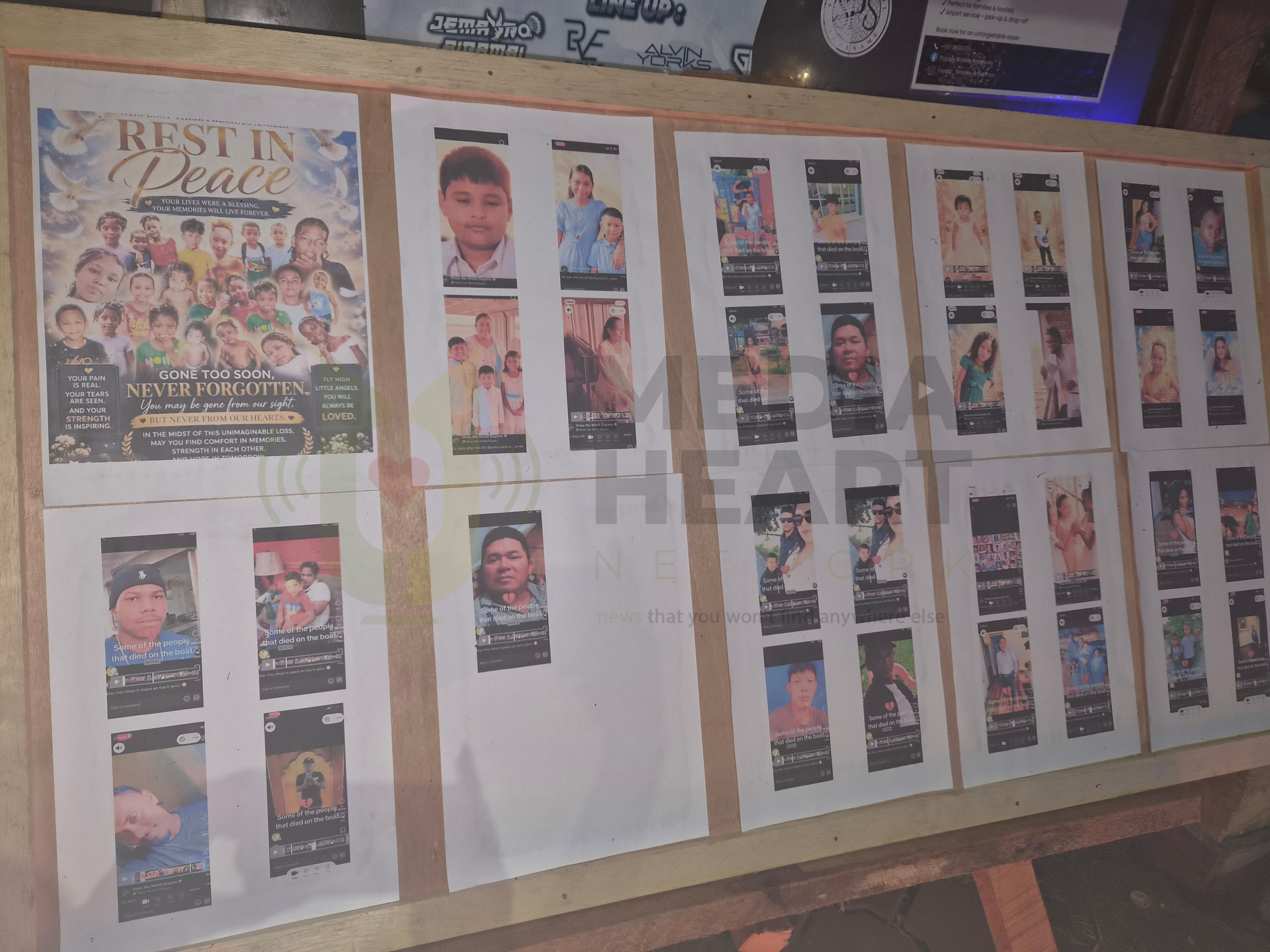 Op het bord staan foto's en namen van de slachtoffers die worden herdacht